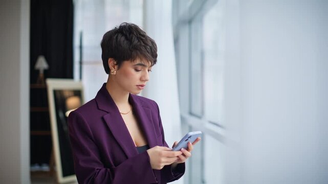 Closeup businesswoman using smartphone standing window. Woman answering email