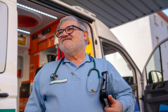 Paramedic wearing stethoscope standing near ambulance
