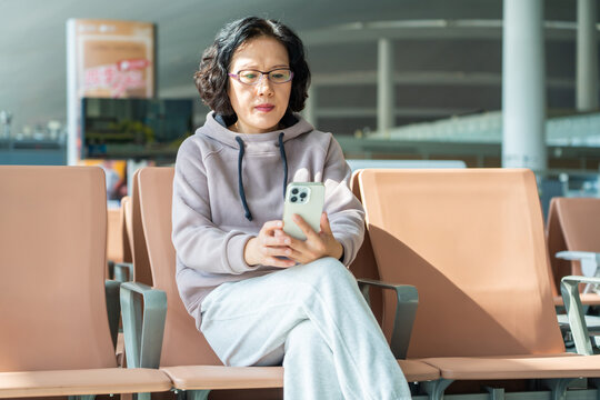 woman using smartphone at airport terminal