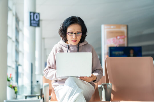 woman working on laptop in airport terminal
