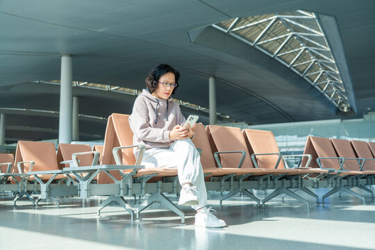 woman using smartphone at airport terminal