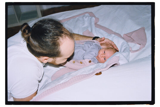 Father gently caring for newborn baby in cozy room