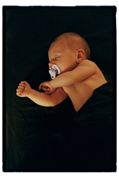 Baby peacefully sleeping with pacifier