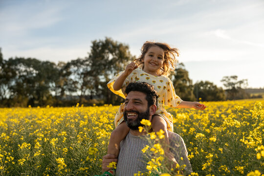 Father and Daughter Walking Through a Sunlit Field