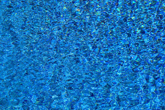 Blue water surface reflecting ripples and light in a swimming pool