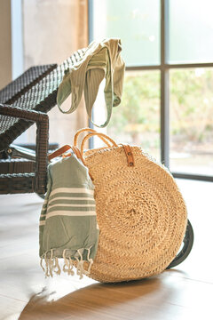 Straw bag with towel and swimwear on a sun lounger