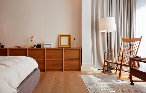 Interior of a corner of the bedroom with a bed and reading chair