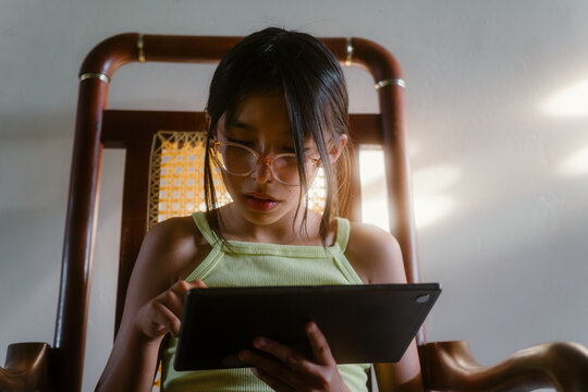 Young girl learning using tablet at home