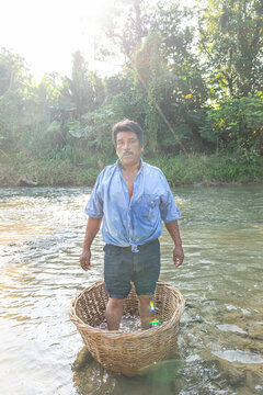 Portrait of a man standing in a basket on a river