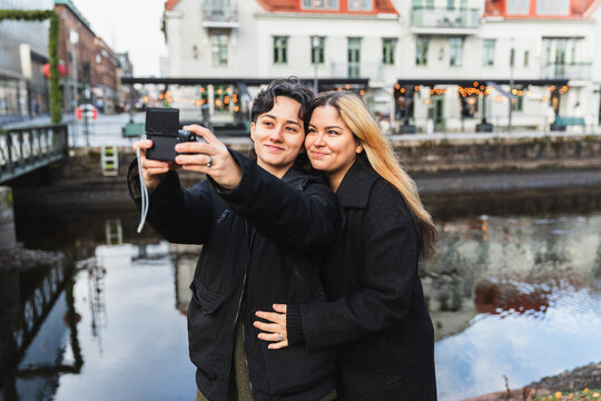 Happy Lesbian Couple Taking Selfie by City Canal