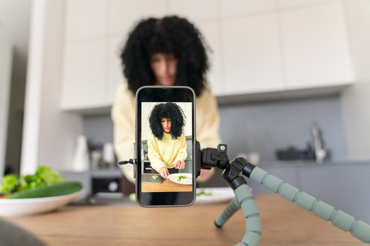 Cooking vlog setup with a mobile phone in a modern kitchen