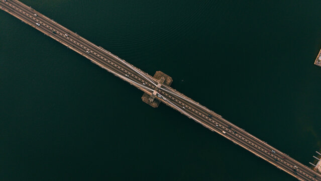Aerial view of Lekki-Ikoyi Link Bridge cutting across a dark green body of water, the road surface reflects light, Lagos, Lagos, Nigeria.