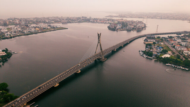 Aerial view of the Lekki-Ikoyi Link Bridge spans the dark waters, connecting the vibrant cityscapes under a hazy sky, Lagos, Lagos, Nigeria.