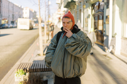Young Person in a Puffy Jacket Walking on City Street in Winter