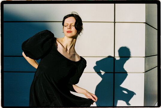 Woman posing in sunlight with strong shadow