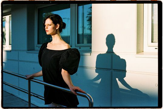 Woman framed by window shadows in afternoon light