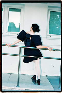 Poised woman leaning back on metal railing