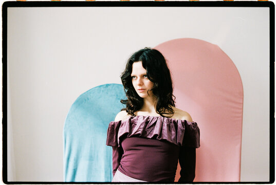 Woman with pink and teal backdrop shapes