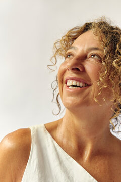 Woman smiling looking away wearing a white dress