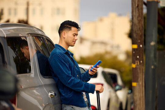 Handsome man leans against his car