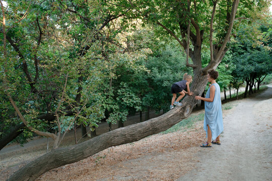 A woman and her son are walking in the park