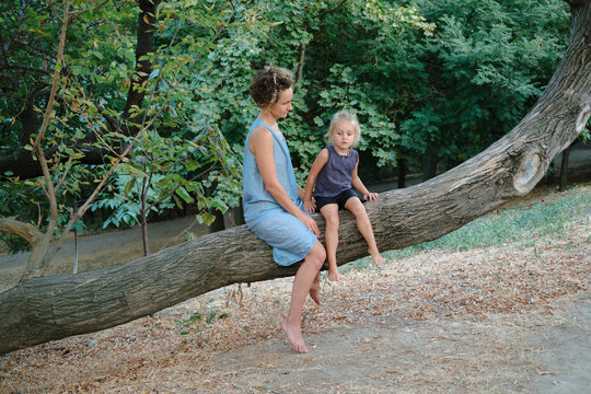 a woman and her son are sitting on a tree