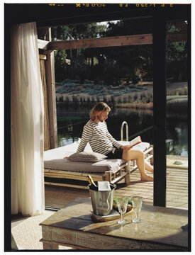A man lounging on a sunbed overlooking a river