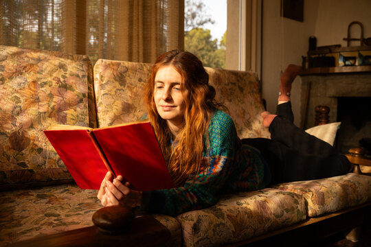 Woman reading  book ON SOFA 