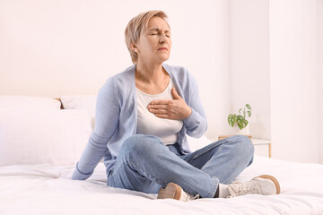 Fototapeta premium Mature woman experiencing menopause in bedroom