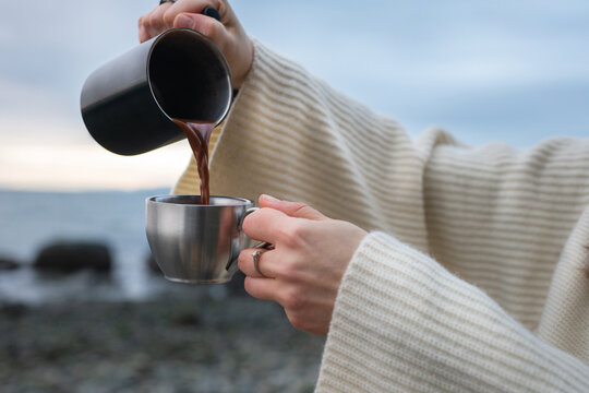 Young woman having a cup of Hot chocolate on the winter beach