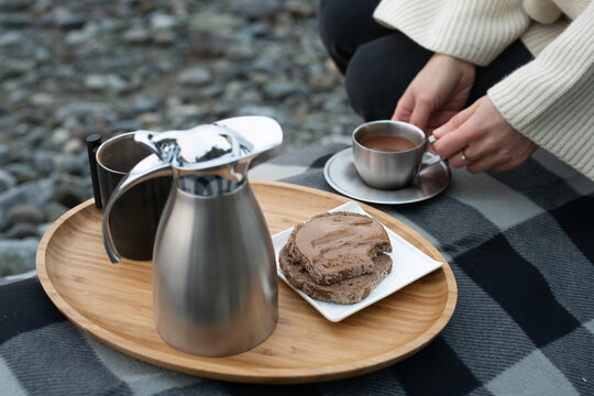 Young woman having a cup of Hot chocolate on the winter beach