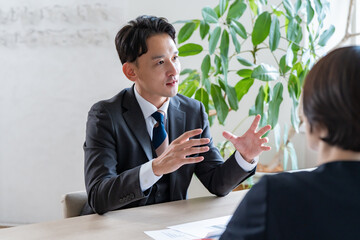 資料を使って商談を進めるビジネスミーティングの様子
