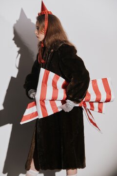 Fashionable woman in fur coat holding Christmas gift