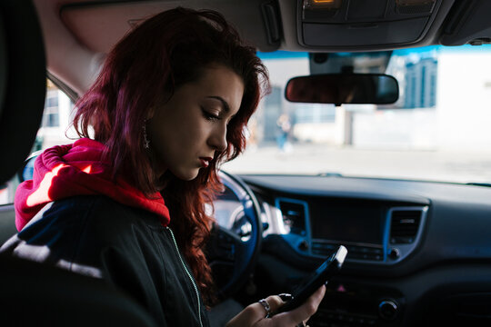 Young woman distracting herself with phone in car