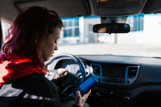 Woman texting on smartphone while driving car