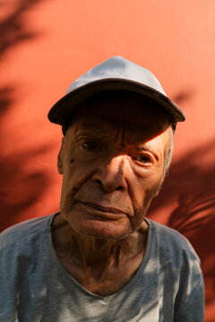 Senior man wearing a cap and gray t-shirt looking at camera