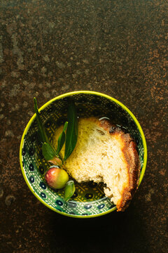 Dipping  bread in a plate with olive oil