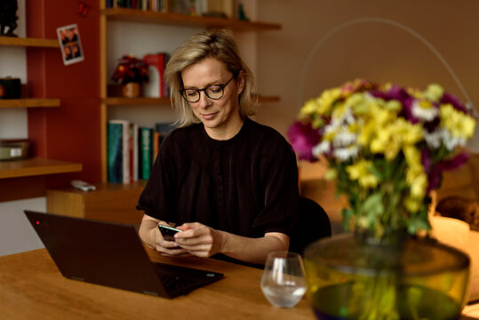 Warm Home Workspace &mdash; Woman Using Smartphone at Her Desk