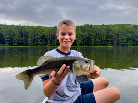 Young boy portrait fishing at lake big bass