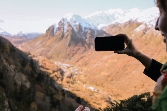 Woman Taking a Picture of a stunning landscape