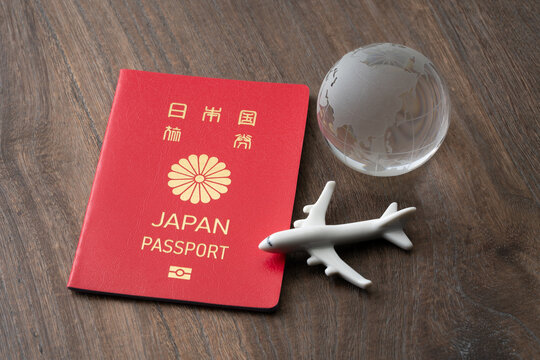 赤い日本のパスポートと旅客機と地球のミニチュア