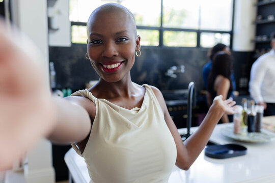 White island countertop gleaming with sink, tall faucet, pan and shelving by windows showing garden