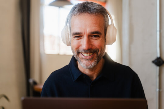 Smiling man talks on a video call.