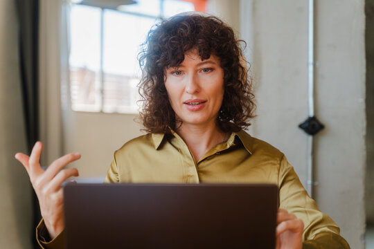Curly woman speaks on a video meeting