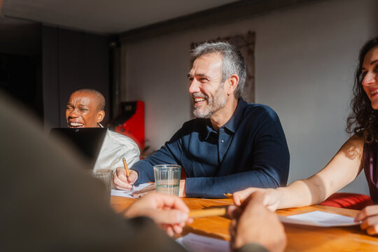 Colleagues engaged in conversation in the conference room