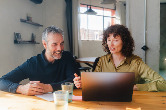 Two people assessing project on laptop