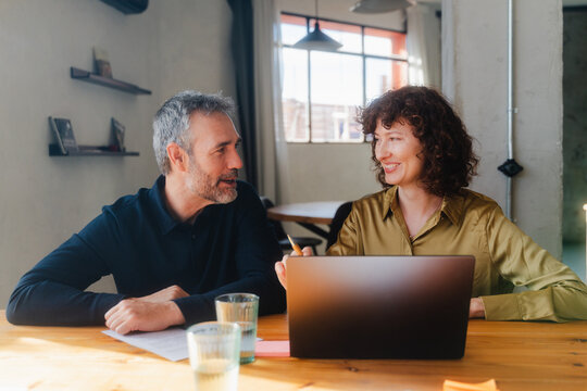 Man and woman reviewing project on a laptop