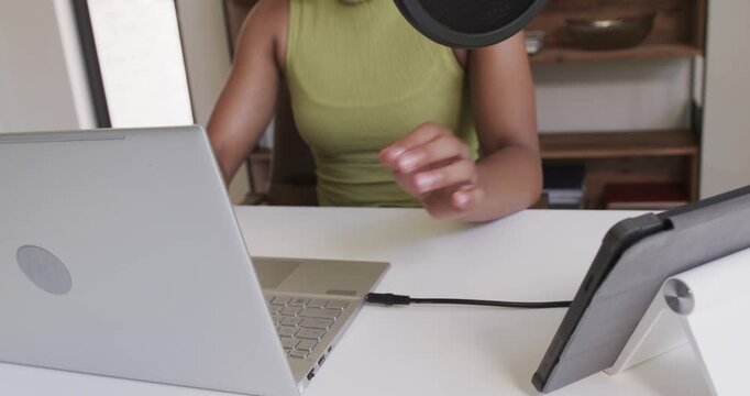 Cable is syncing laptop and tablet on desk, displaying notes for recording while mic is waiting