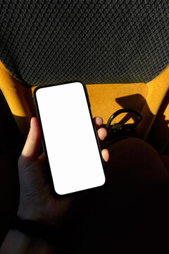 Hand Holding a Smartphone with Blank Screen Sitting by Bus Window