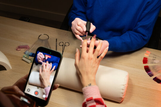 Nail salon with customer getting manicure and recording video